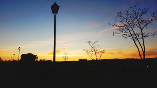 Silhouette trees against sky at sunset