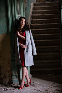 Portrait of woman standing against wall