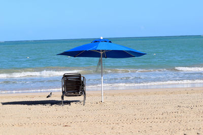 Lifeguard chair on beach against clear sky