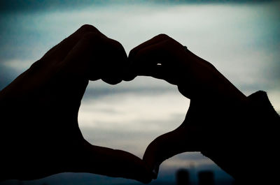 Silhouette heart shape against sky at sunset