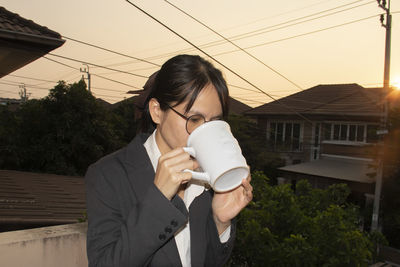 Mid adult woman holding coffee cup