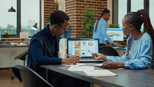 Side view of business colleagues working in office