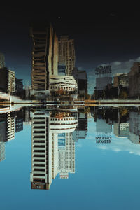 Reflection of buildings in swimming pool against sky