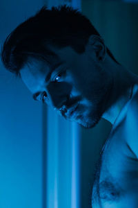 Portrait of shirtless man in darkroom
