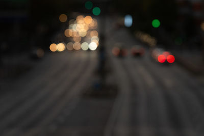 Defocused image of illuminated lights on road at night
