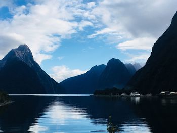 Scenic view of lake by mountains against sky