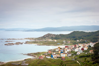 High angle view of buildings by sea against sky