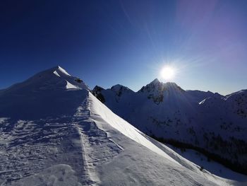 Scenic view of snowcapped mountains against blue sky
