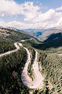 Aerial view of winding road on mountains against cloudy sky