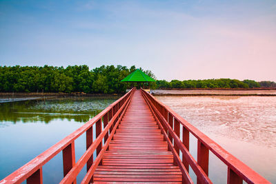 View of wooden bridge over calm lake