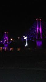 Illuminated lights in city against sky at night