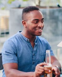 Smiling young man drinking beer