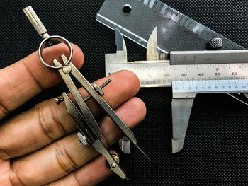 Cropped hand with tools at table