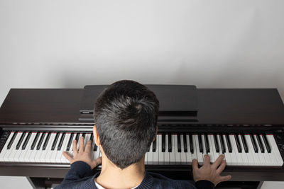 Rear view of men playing piano