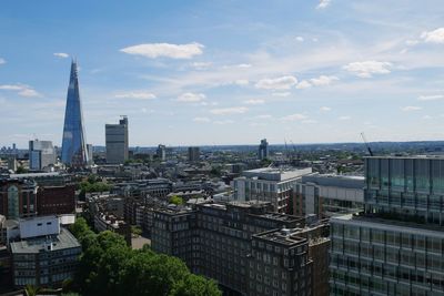 Buildings in city against cloudy sky