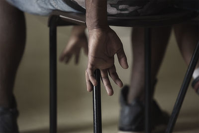 Low section of man sitting on chair at home