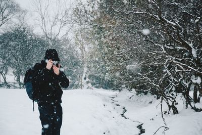 Full length of woman photographing during winter