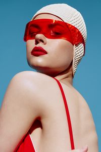 Portrait of woman wearing hat against blue background