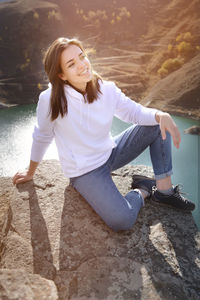 Portrait of smiling young woman sitting outdoors