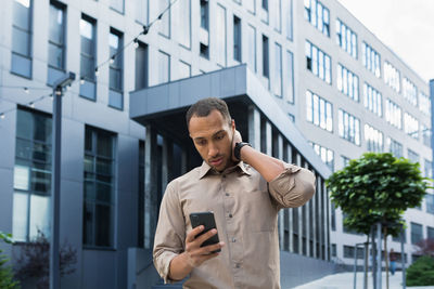 Young man standing against building