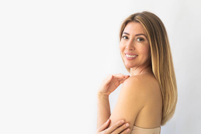 Portrait of young woman against white background