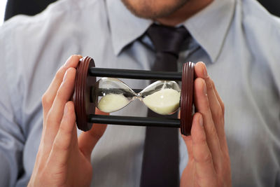 Close-up midsection of businessman holding hourglass