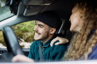 Portrait of smiling young man sitting in car