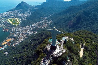 High angle view of cross amidst trees and buildings in city