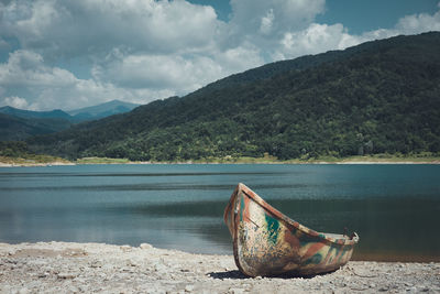 Abandoned boat moored on lakeshore