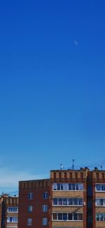 Low angle view of buildings against clear blue sky