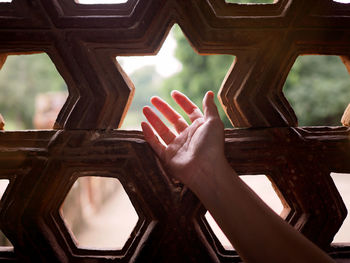 Close-up of hand on window