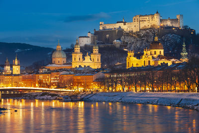 Illuminated buildings in city at dusk