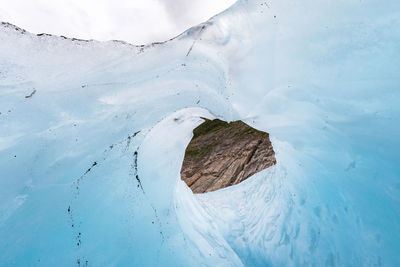 Low angle view of ice formation against cloudy sky