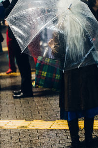 Low section of people walking on wet street