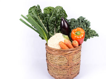 Close-up of vegetables in basket against white background