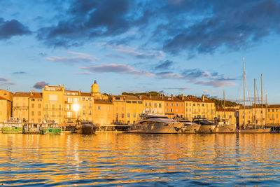 Scenic view of saint-tropez in golden sunset light against dramatic sky