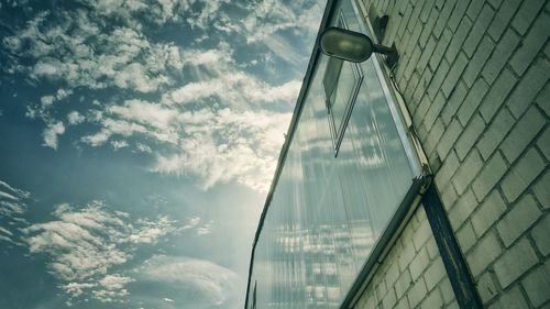 Low angle view of glass building against sky