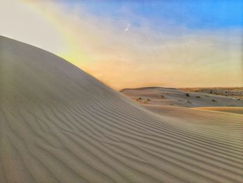 Scenic view of desert against sky during sunset