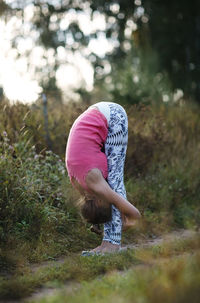 Woman exercising against trees