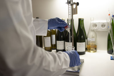 Close up of lab technician by placing a sample on beaker.