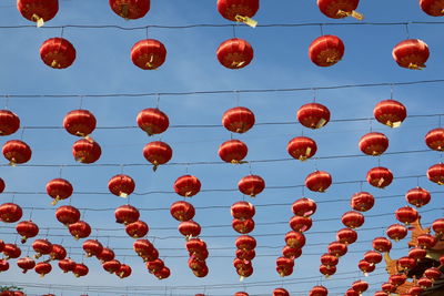 Low angle view of lanterns hanging against sky