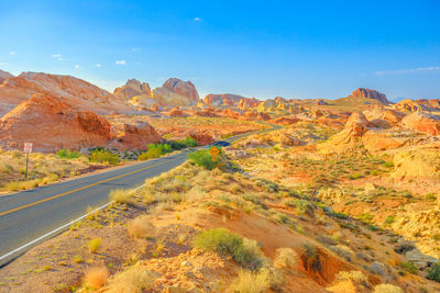 Scenic view of road amidst rocky mountains against sky