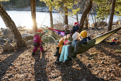 Children on hammocks by lake