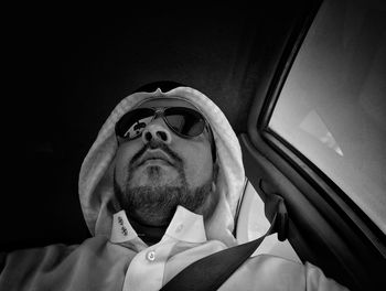 Low angle view of man wearing dish dash while traveling in car