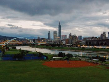 Buildings in city against cloudy sky