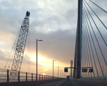 Low angle view of crane against sky during sunset