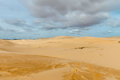 Scenic view of sand dunes against sky