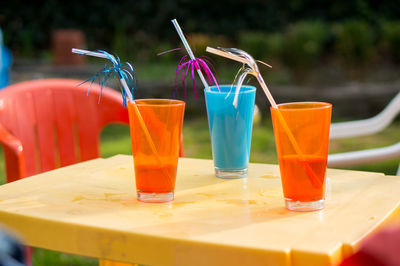 Colorful glasses with decorative straws on table at restaurant