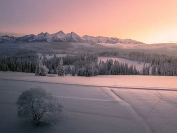Scenic view of snowcapped mountains against sky during sunset