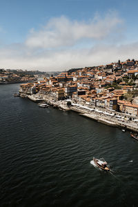 High angle view of buildings by river against sky